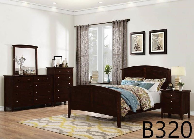 A bedroom with a bed , dresser , nightstand , mirror and rug.