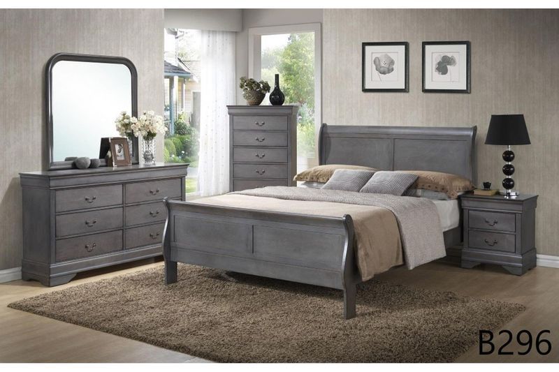 A bedroom with a bed , dresser , nightstand and mirror.