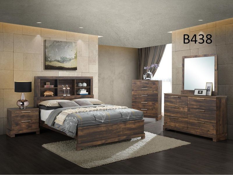 A bedroom with a bed , dresser , nightstand and mirror.