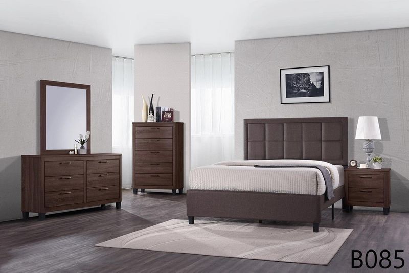 A bedroom with a bed , dresser , nightstand , mirror and rug.