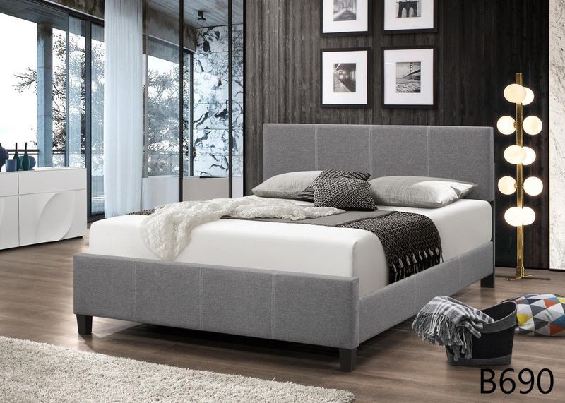 A bed is sitting in a bedroom next to a lamp.