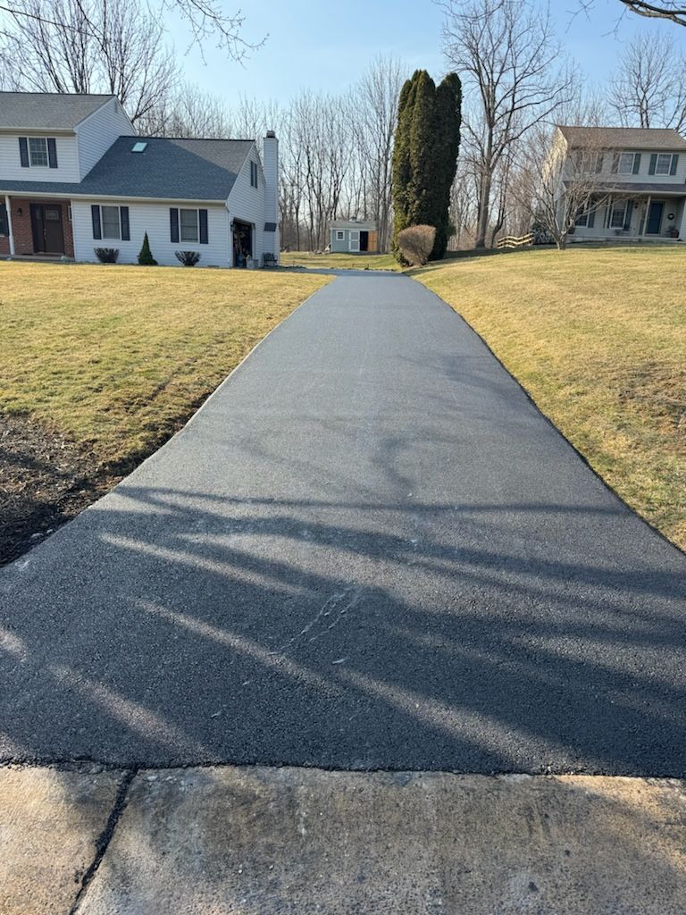A newly paved driveway leading to a house.