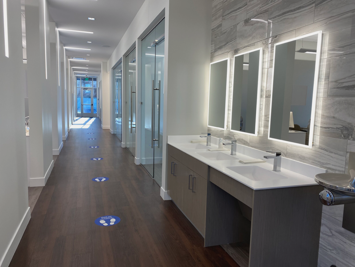 Pure Orthodontics interior...  a long hallway with three sinks and mirrors in a dental office.