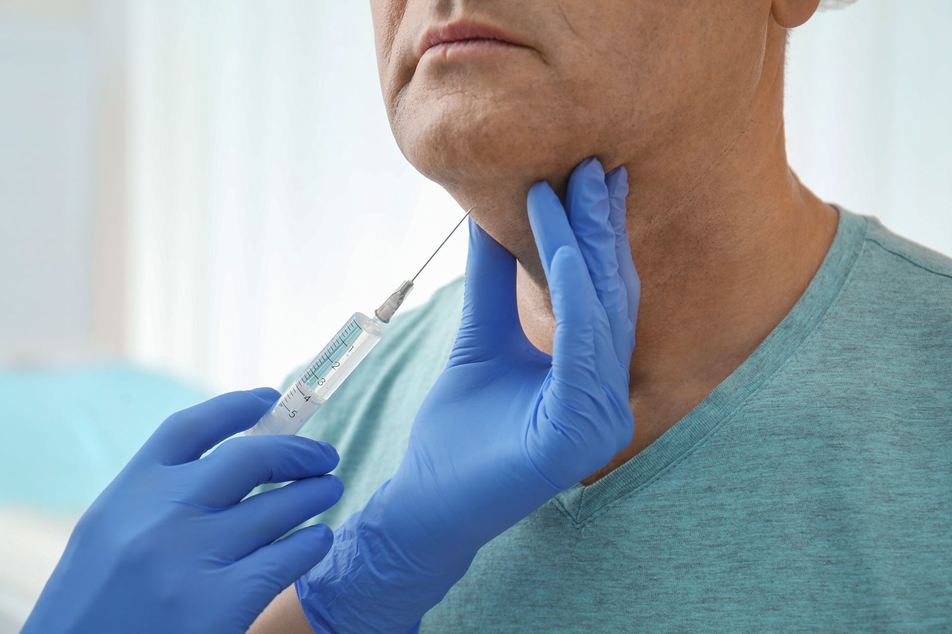 A man is getting an injection in his neck by a doctor.