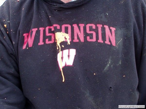 Close-up of a black Wisconsin hoodie with red lettering and a large white W logo, stained with spilled food.
