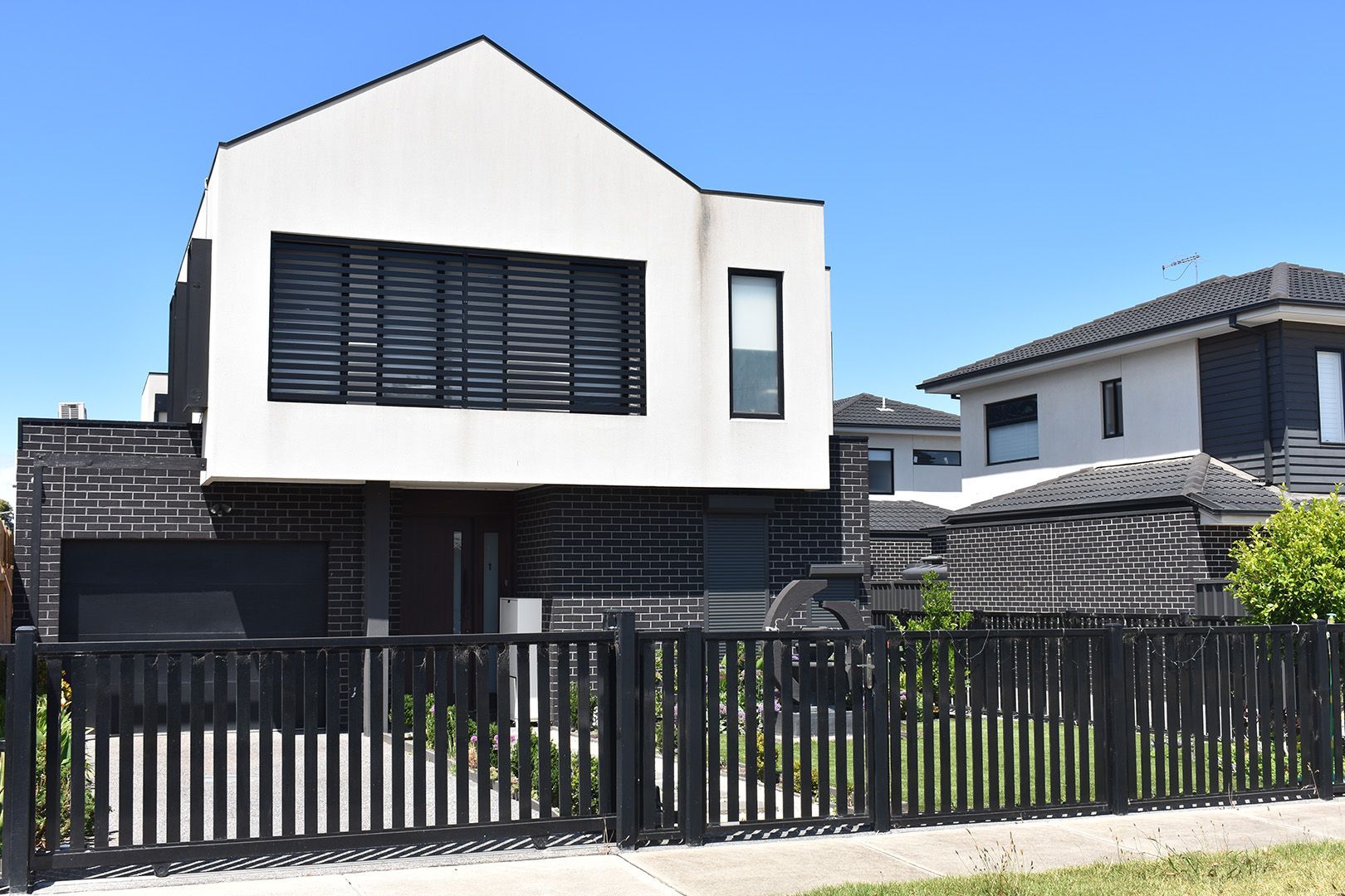 Hands aligning fiber optic cables in a fusion splicer, with tools and testing equipment on a black surface.