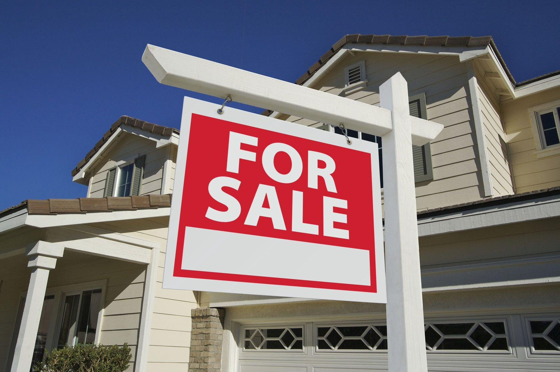 A house with a for sale sign in front of it