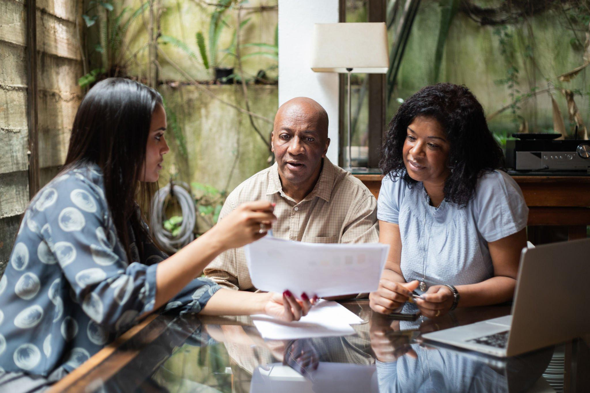 A group of people are sitting at a table looking at a piece of paper.
