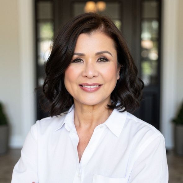 A woman with dark hair is smiling for the camera