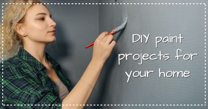 A woman is painting a wall with a brush.