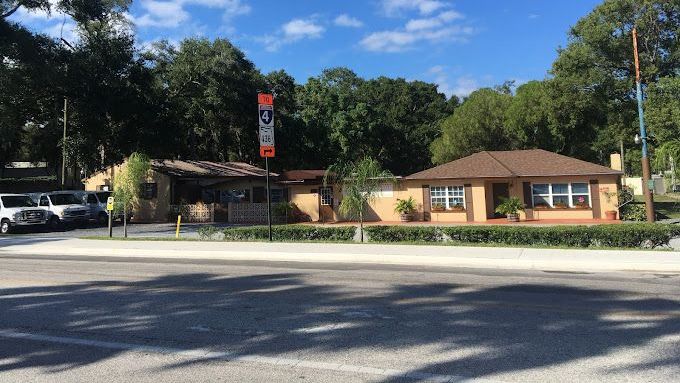 A house is sitting on the side of a road surrounded by trees.