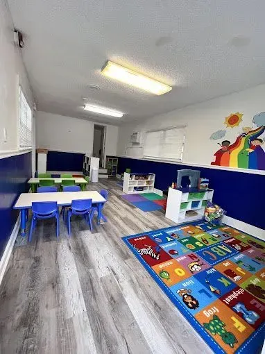 Bright classroom with wooden furniture, educational materials, and a calendar.