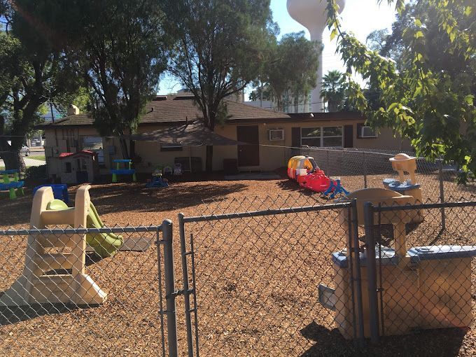 A playground with a chain link fence and a water tower in the background