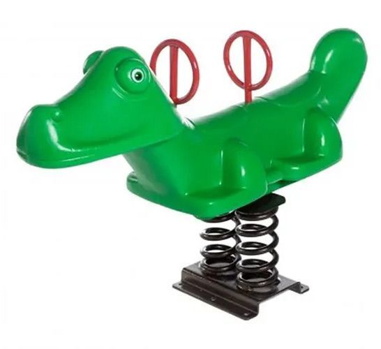 Green alligator spring rider with red handles on a playground.