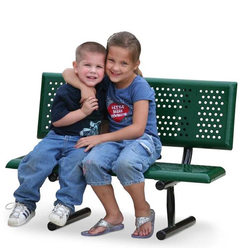 Two children sit close, smiling on a green bench. The boy has an arm around the girl.