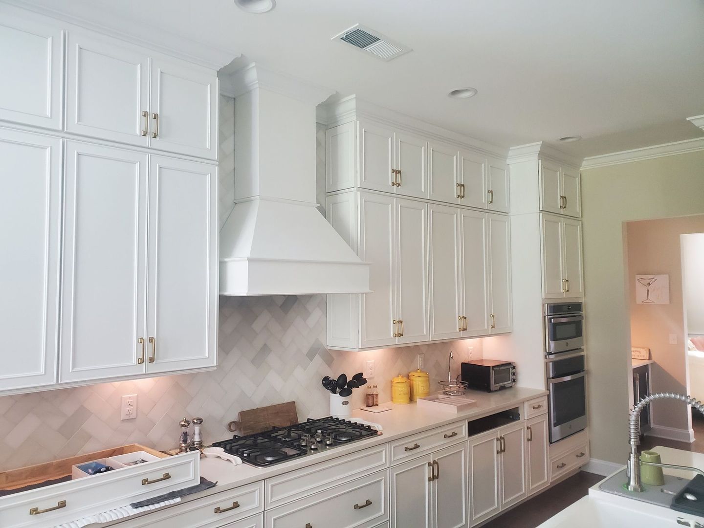 A kitchen with white cabinets and a stove top oven