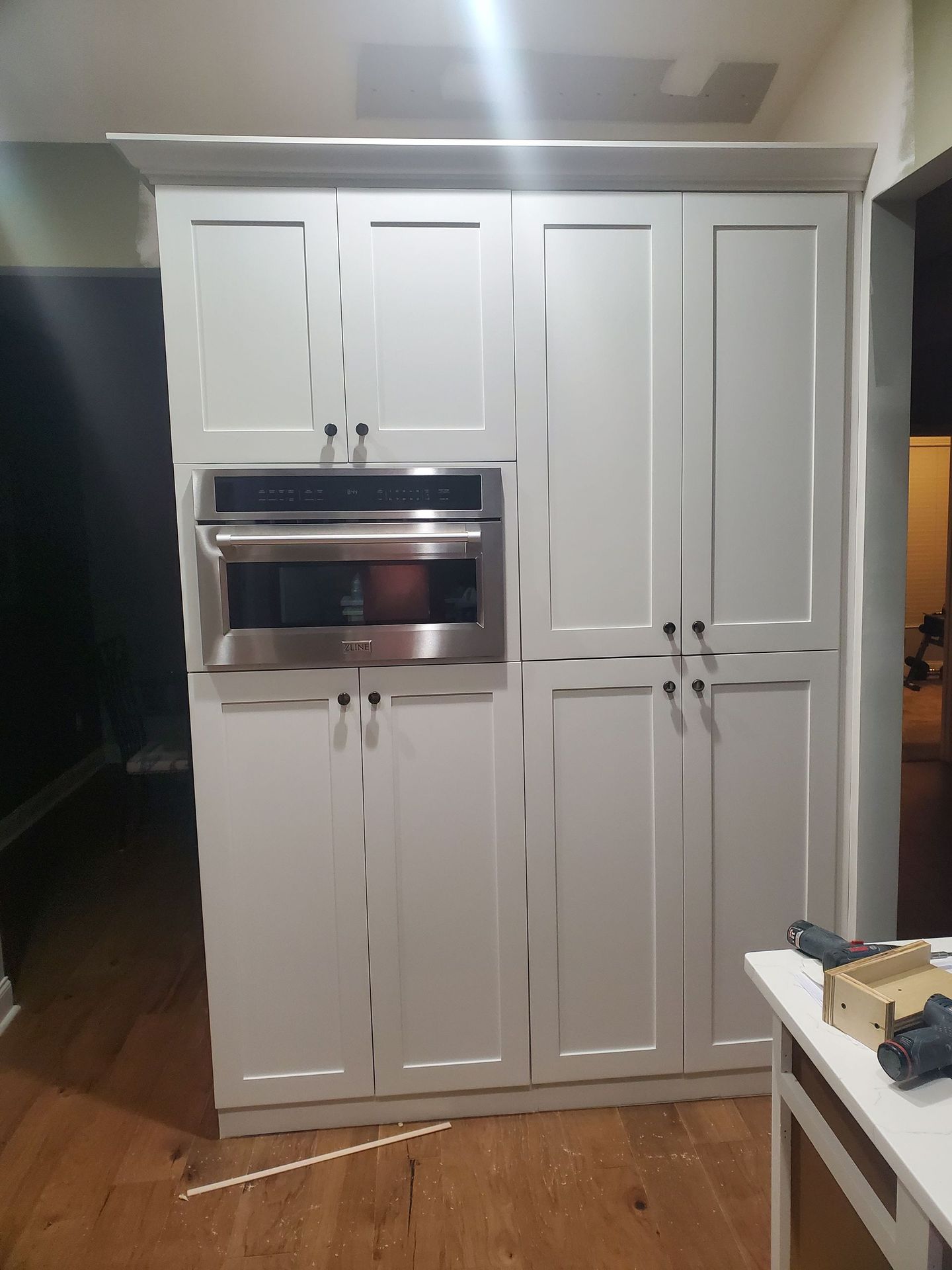 A kitchen with white cabinets and a stainless steel oven.