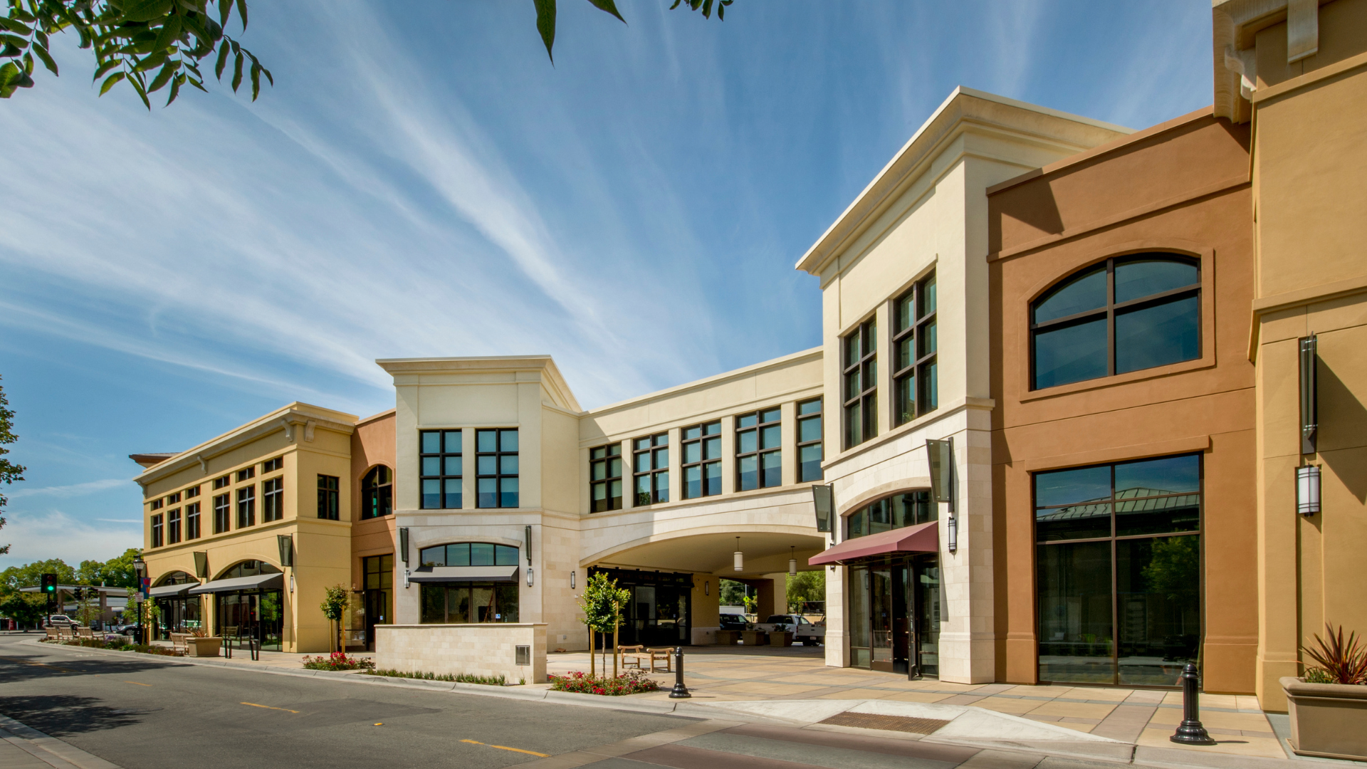 Multi-story commercial buildings in shades of beige and brown under a blue sky.