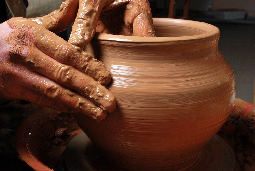 A person is making a pot on a pottery wheel.