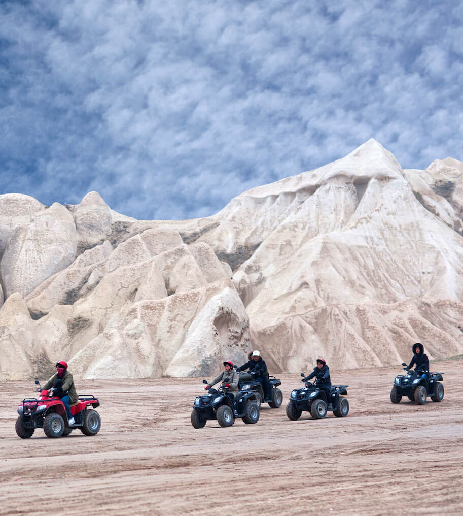 A group of people are riding atvs in the desert