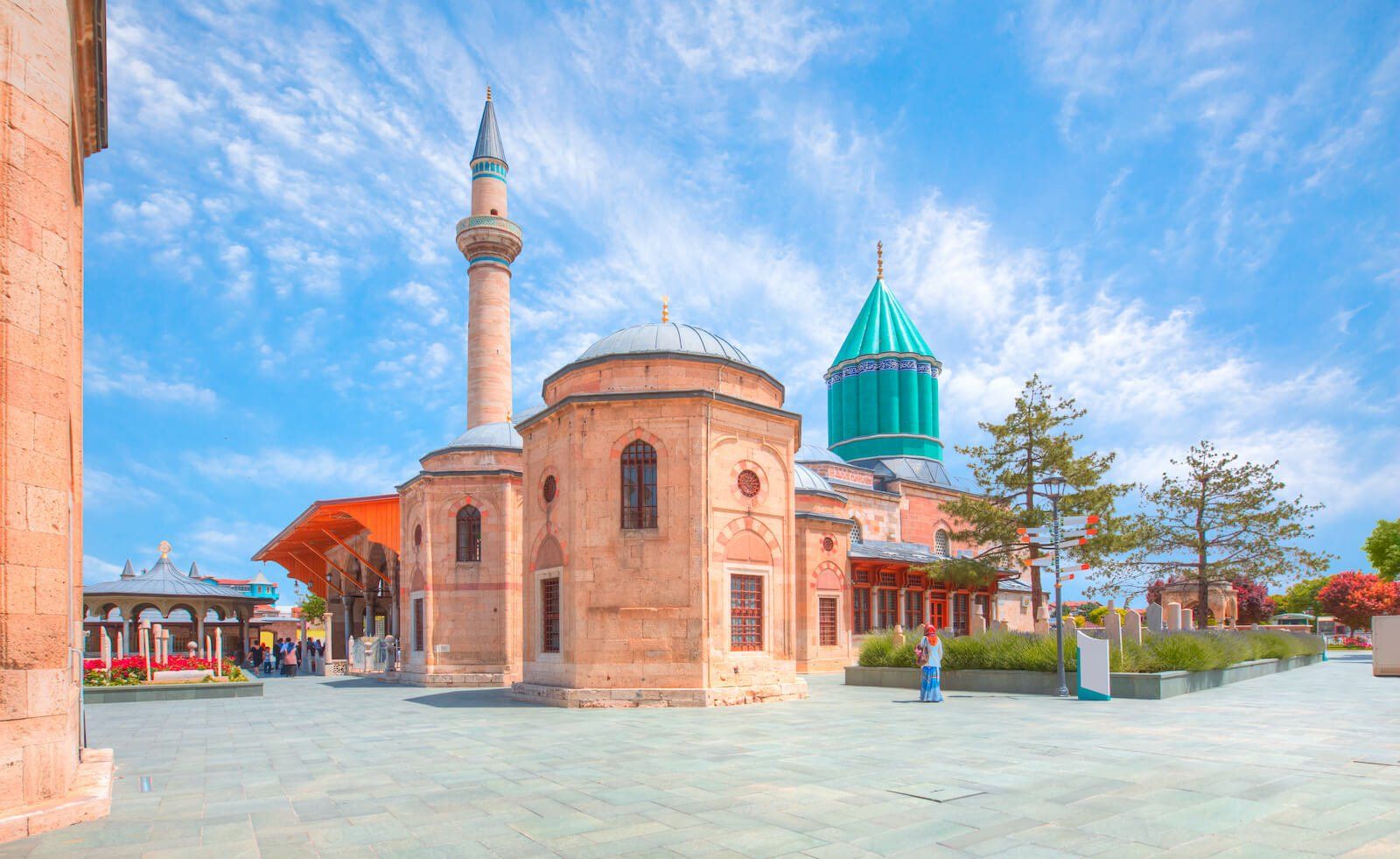 A mosque with a green dome and a minaret on a sunny day.