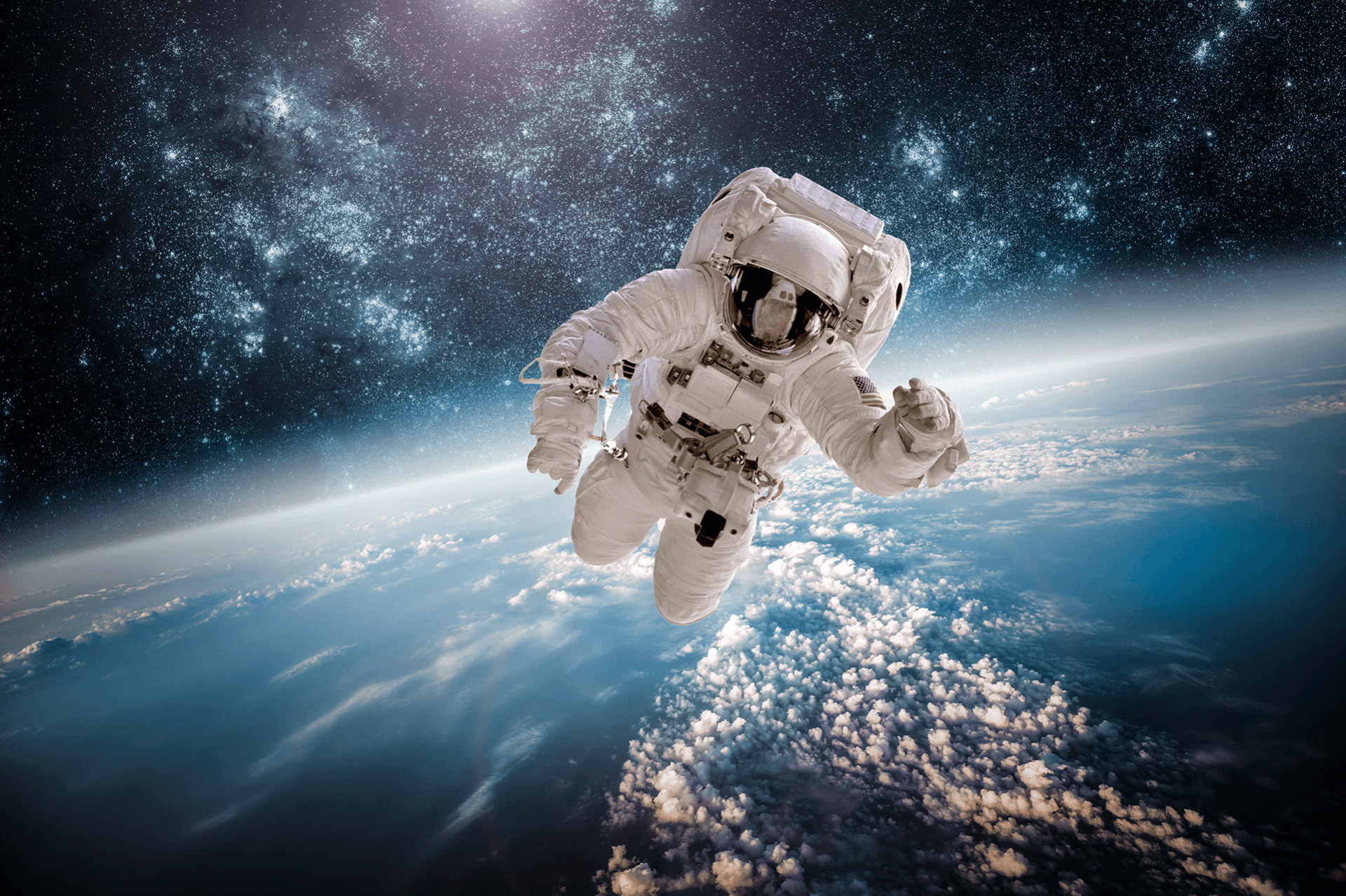 An astronaut is floating in space above the earth.