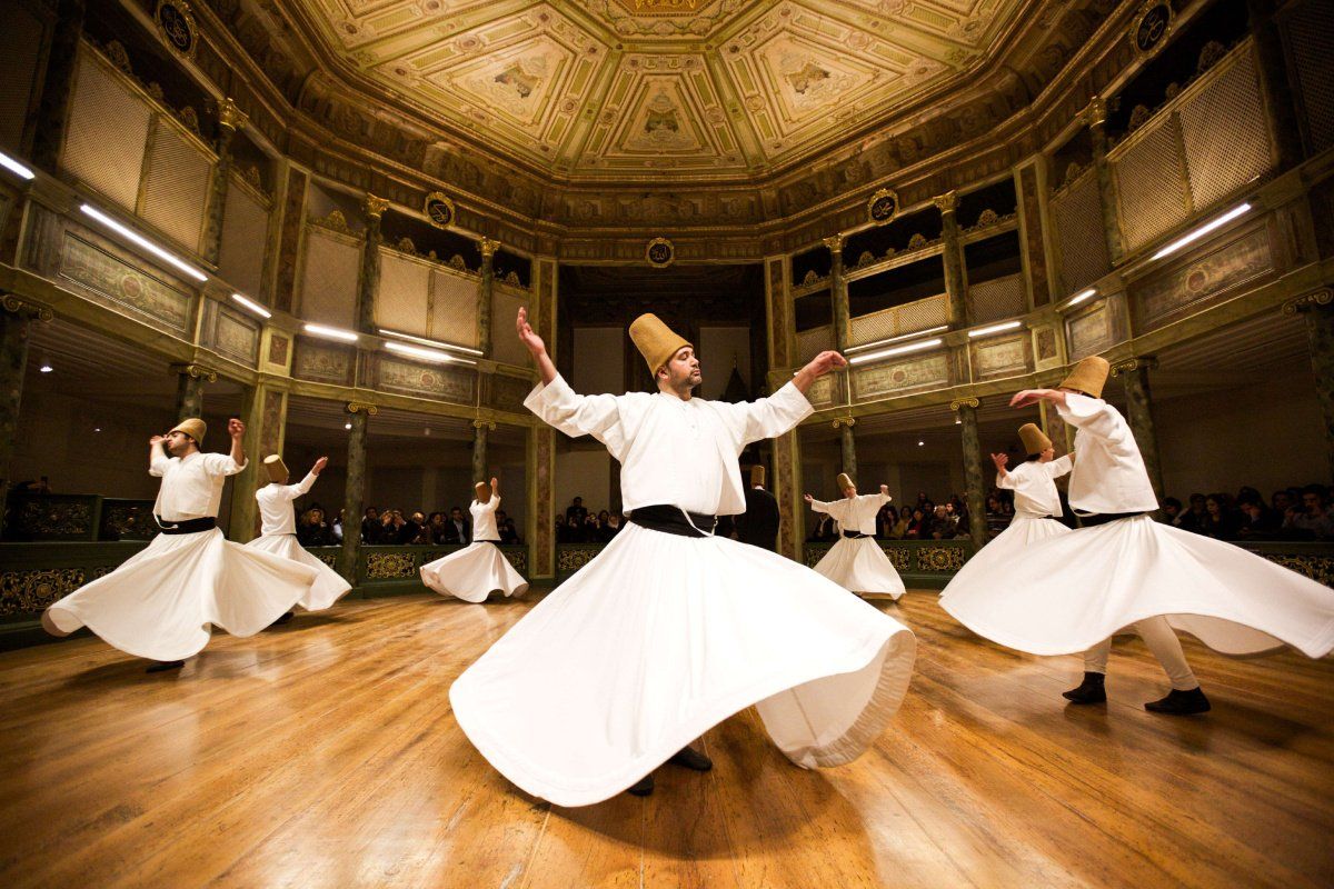 A group of men are dancing in a large room.