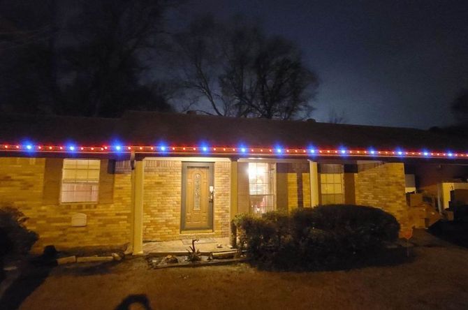 A house is decorated with christmas lights at night.