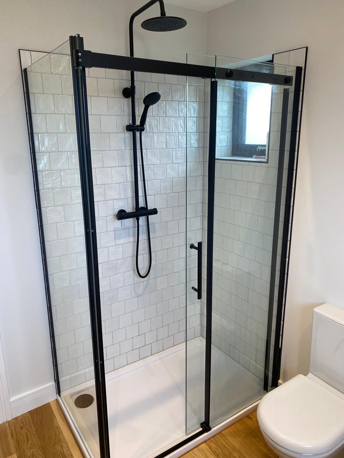 A bathroom with a shower stall and a toilet.