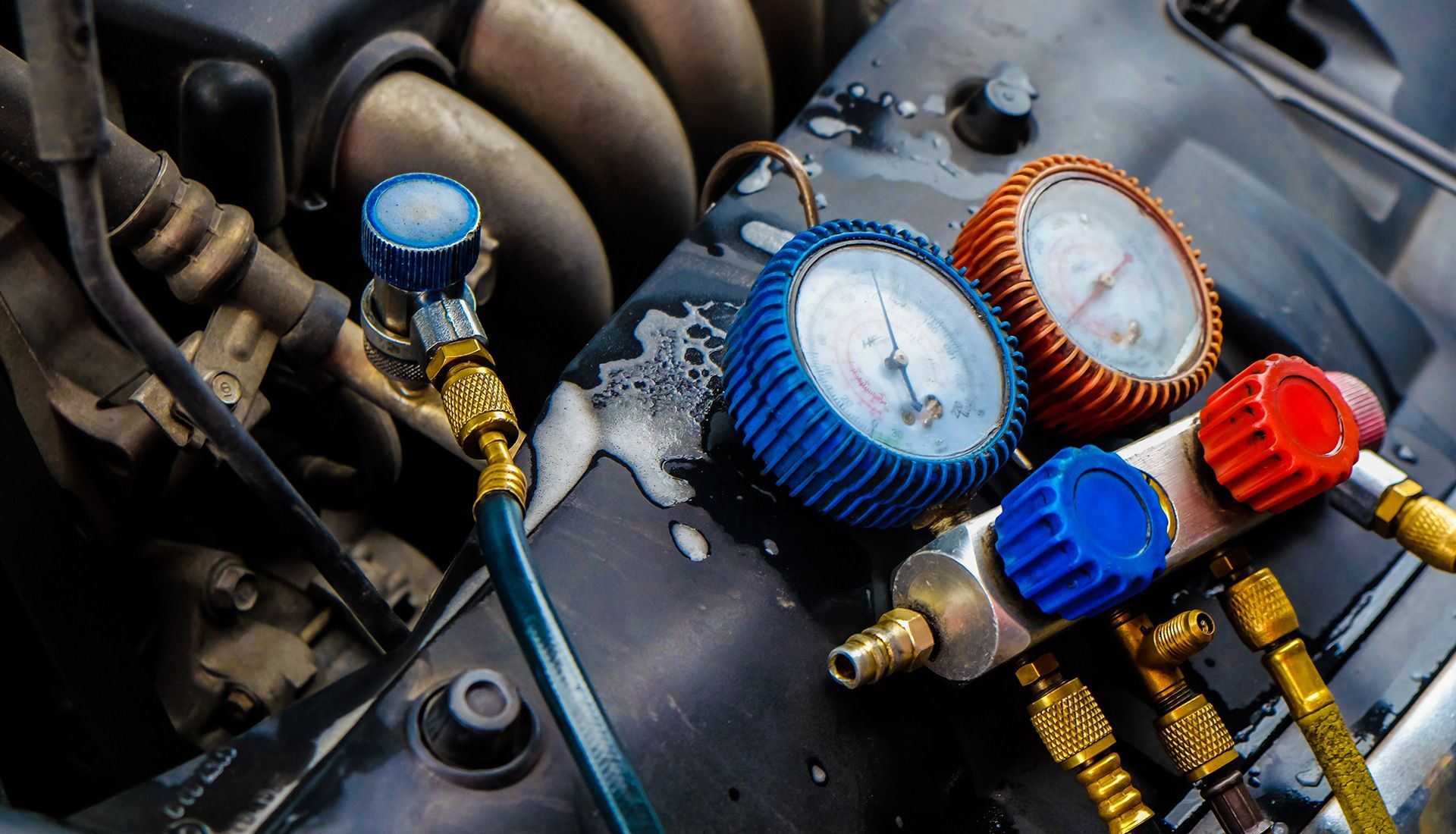 Car engine with gauges connected, showing pressure readings.