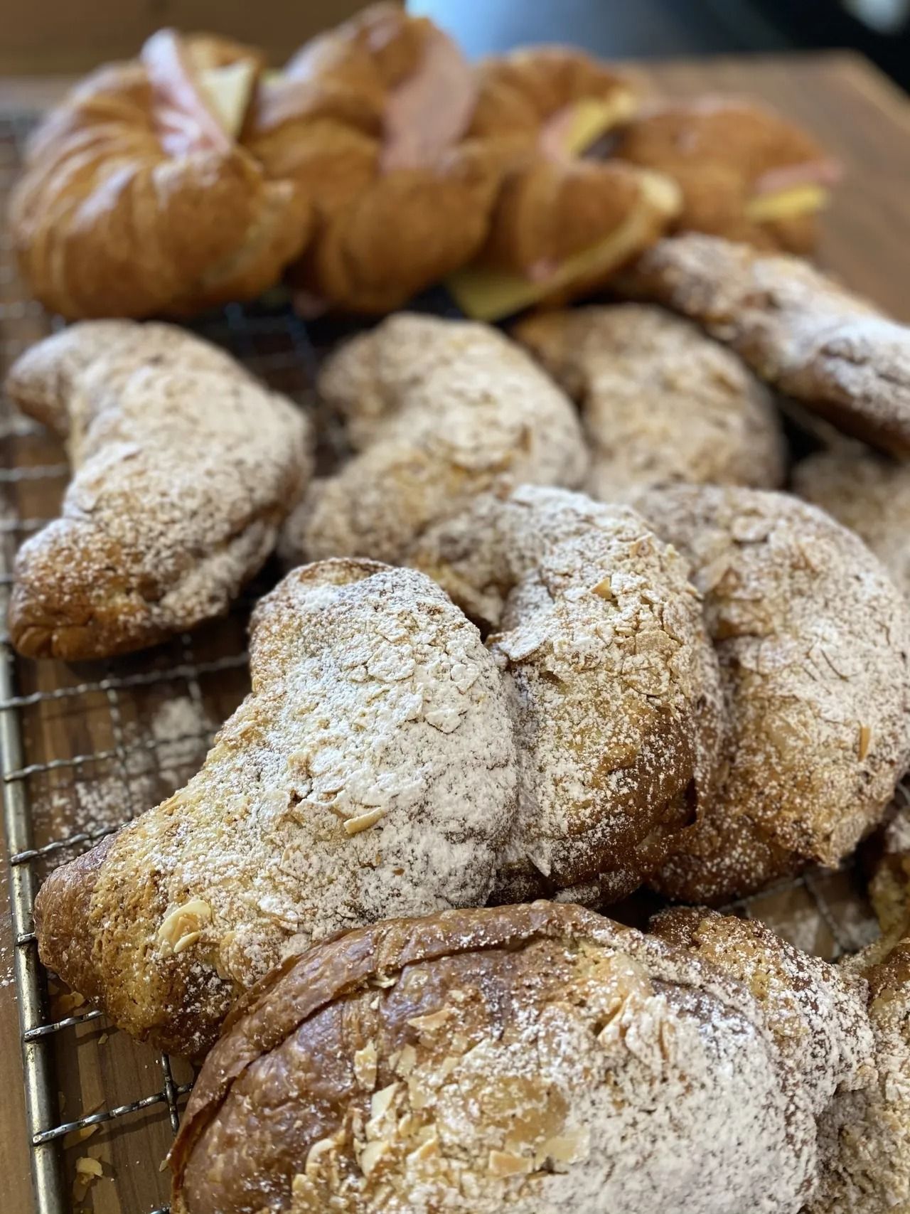 A bunch of pastries are sitting on a cooling rack.