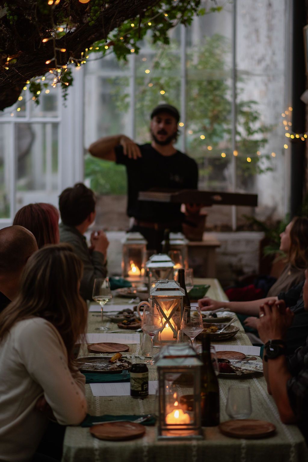 Chef Talking To Guests On A Long Table.