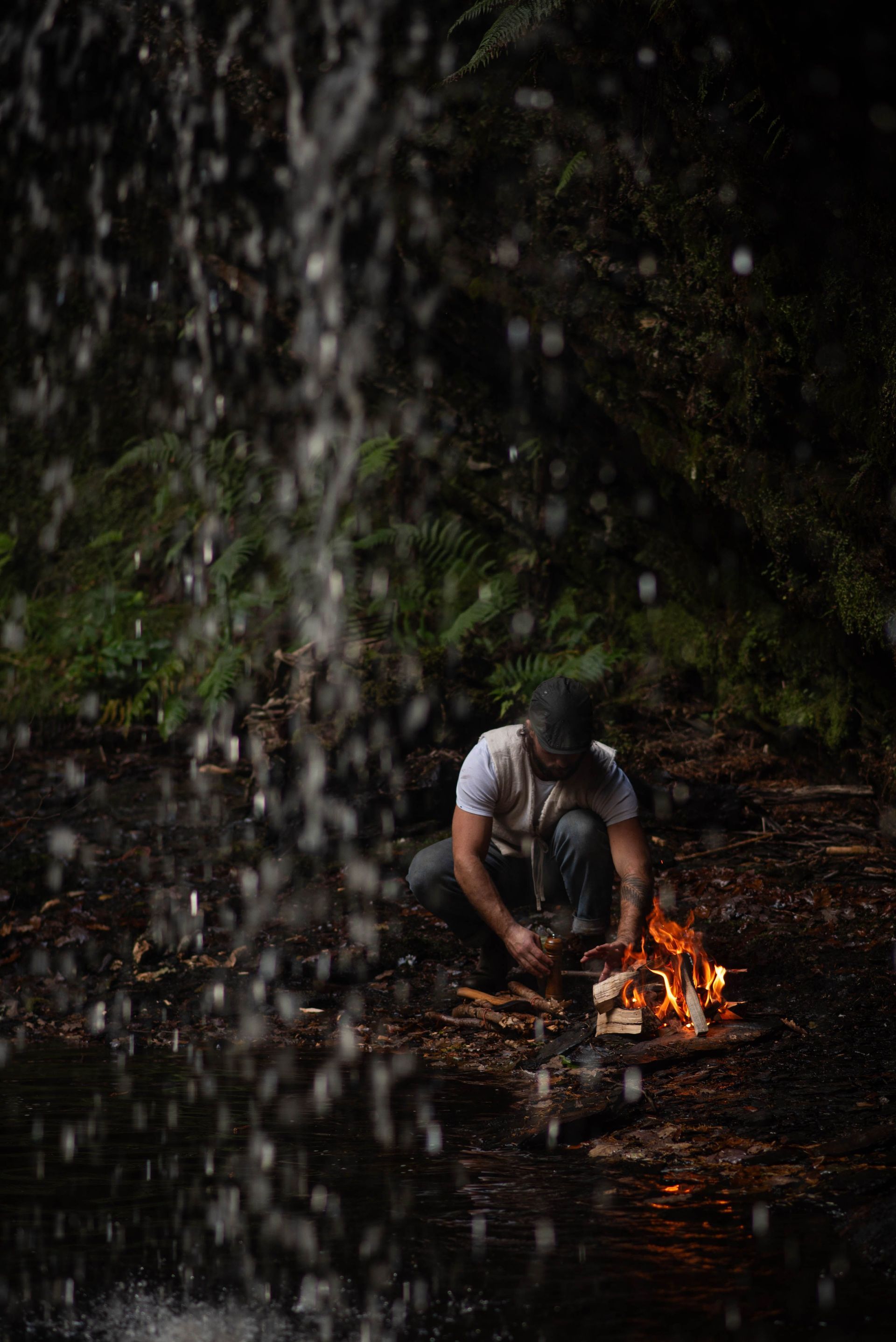 Chef cooking cast iron pot over a flame.