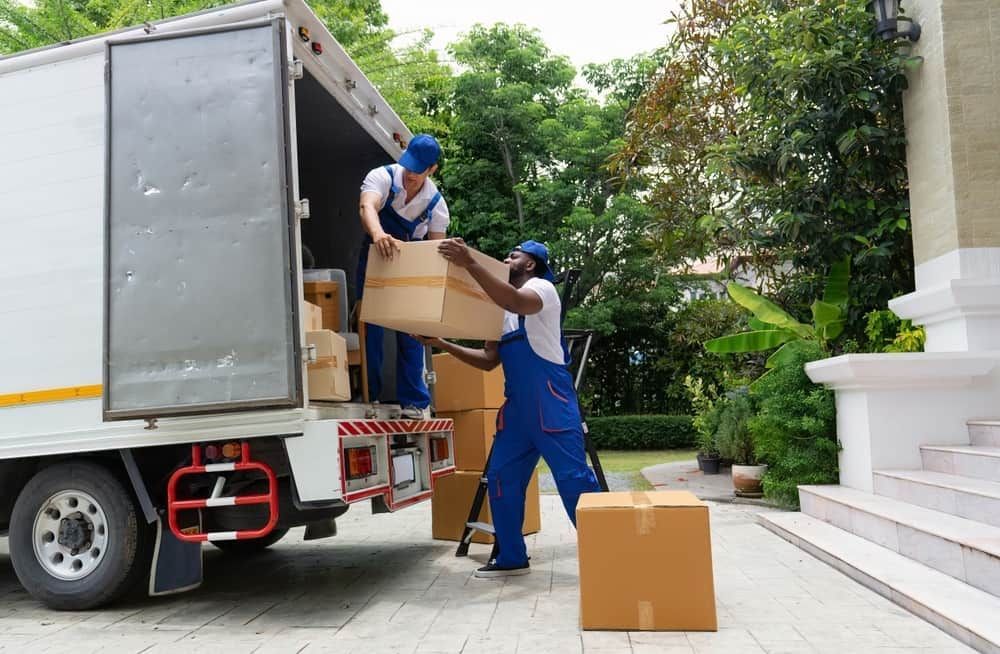 Two Men Are Loading Boxes Into A Moving Truck — Byron Coast Removals In Brunswick Heads, NSW