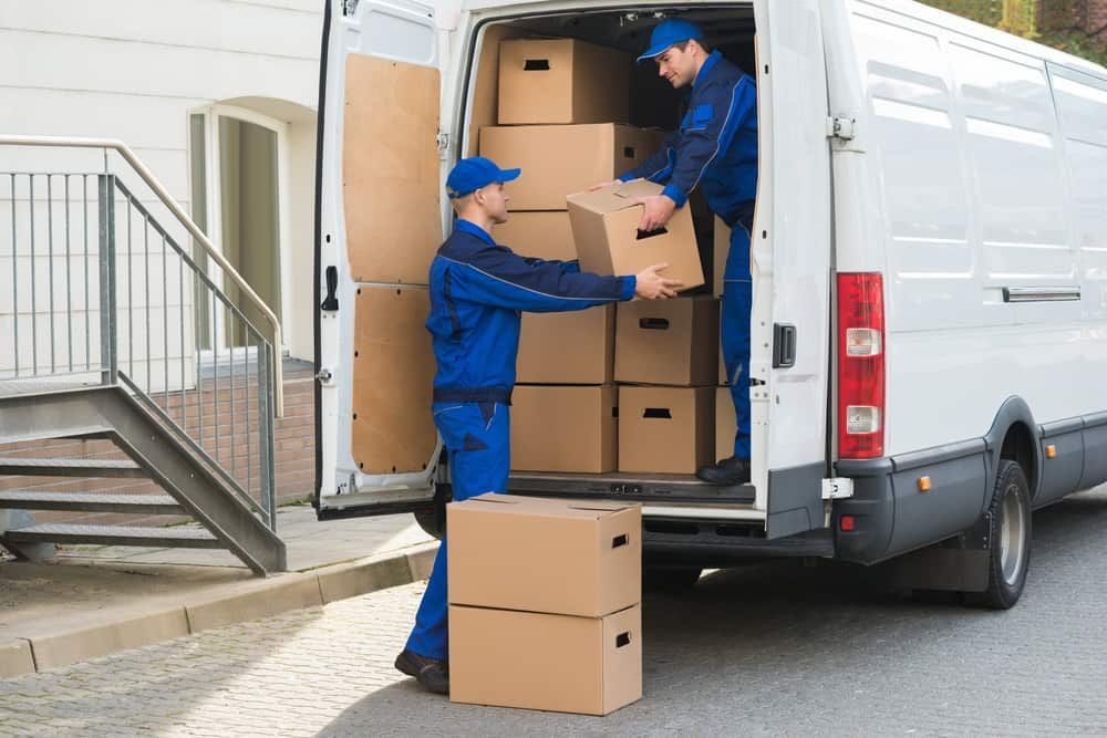 Two Delivery Men Are Loading Boxes Into A Van — Byron Coast Removals In Main Arm, NSW