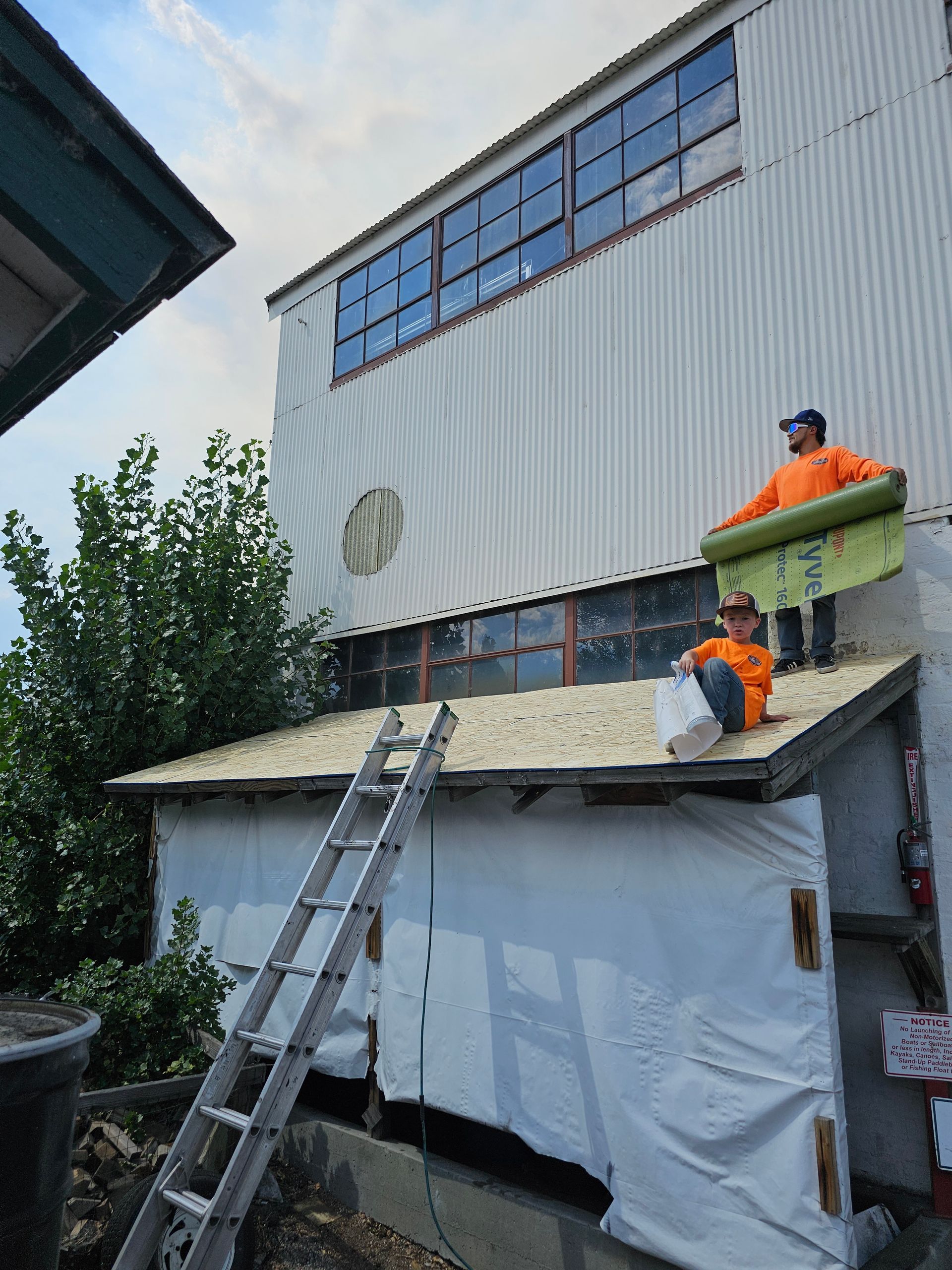 Two men are working on the roof of a building.