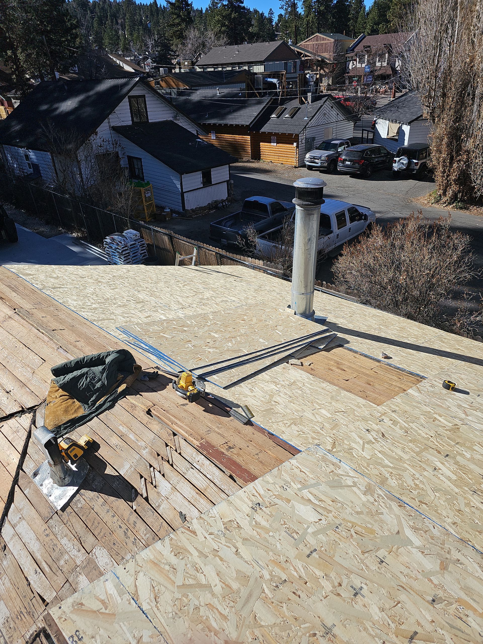 A person is working on a roof with a pair of gloves on it.