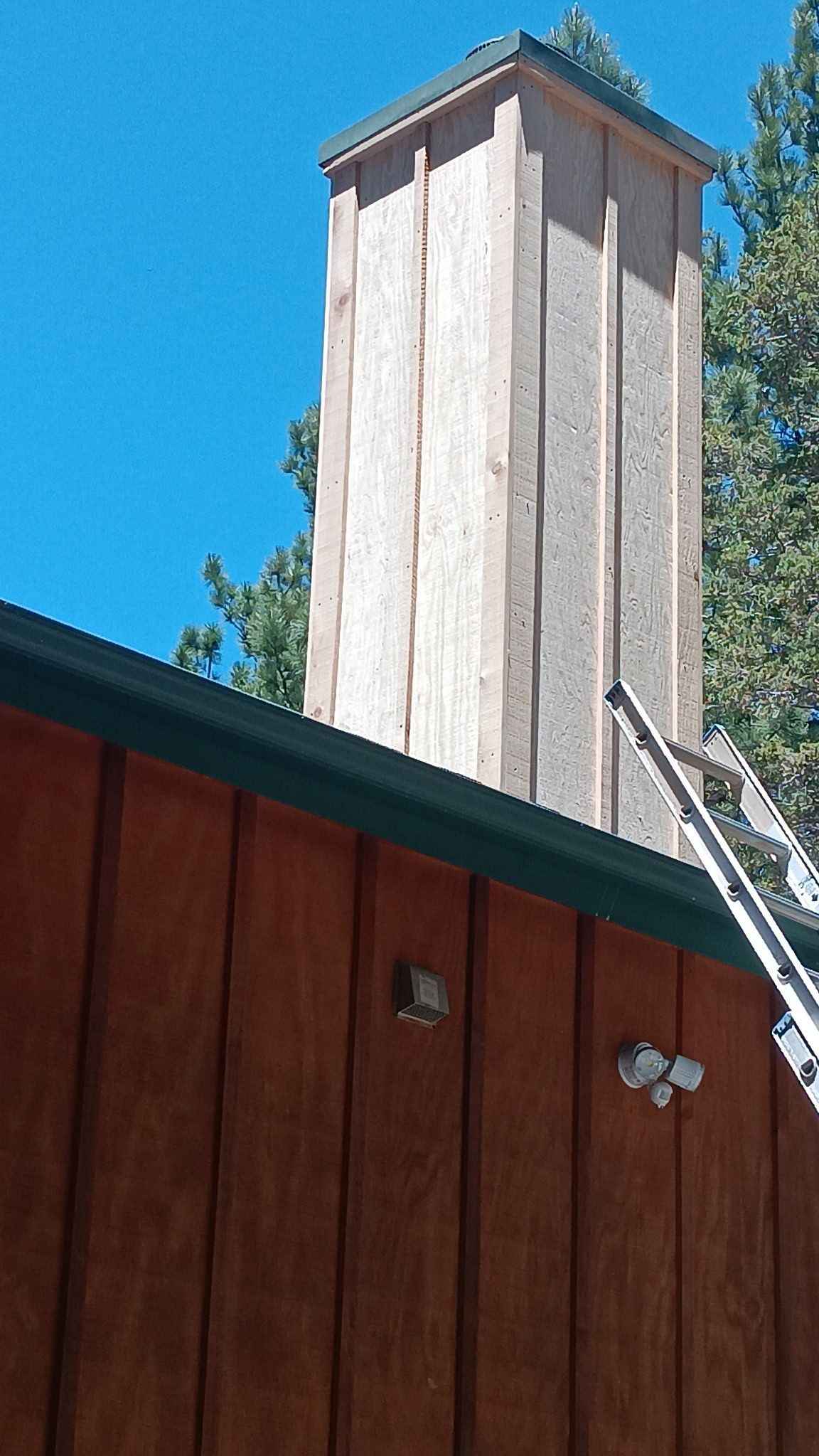 A wooden chimney is sitting on top of a wooden building.