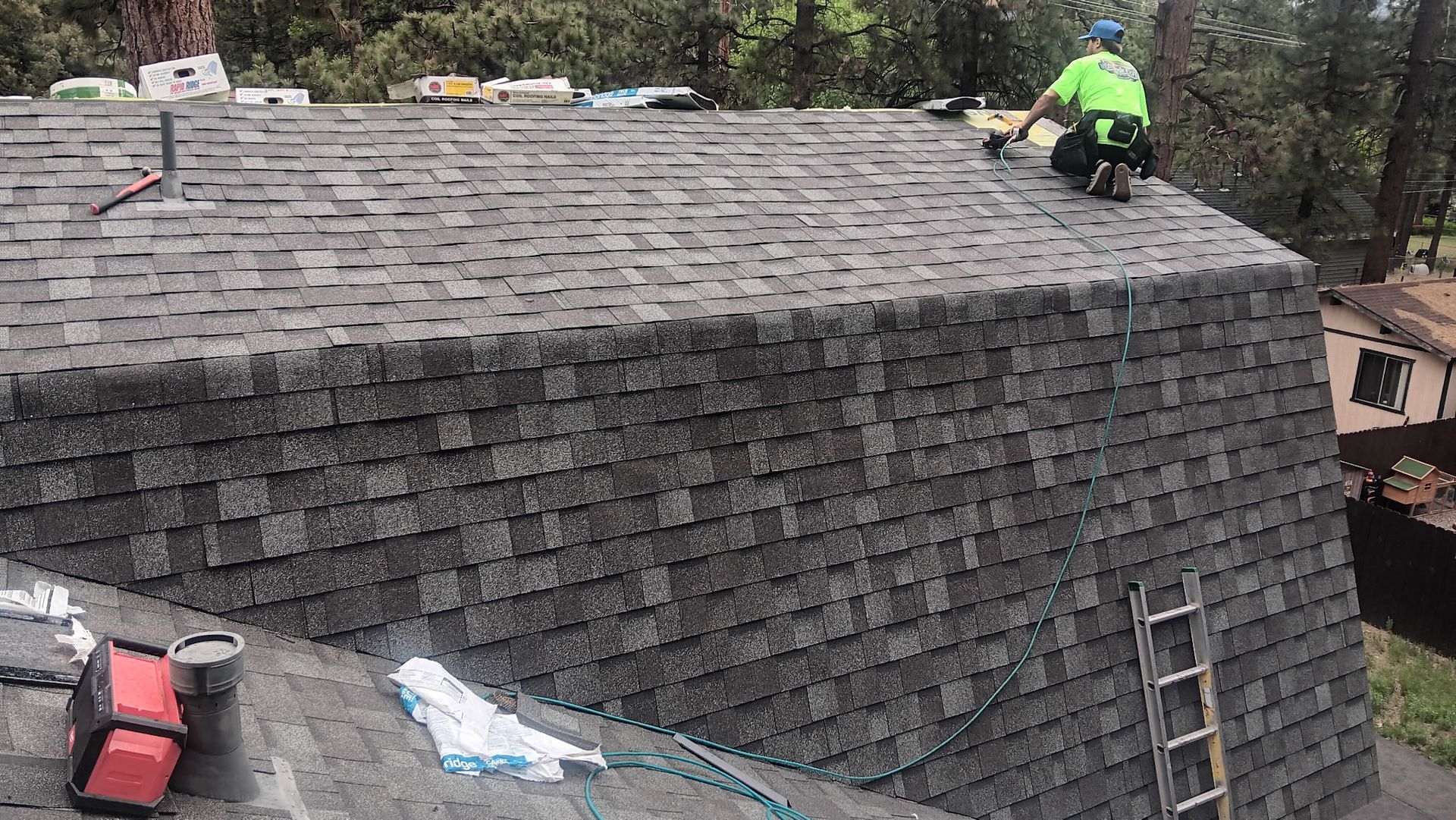 A man is working on the roof of a house.