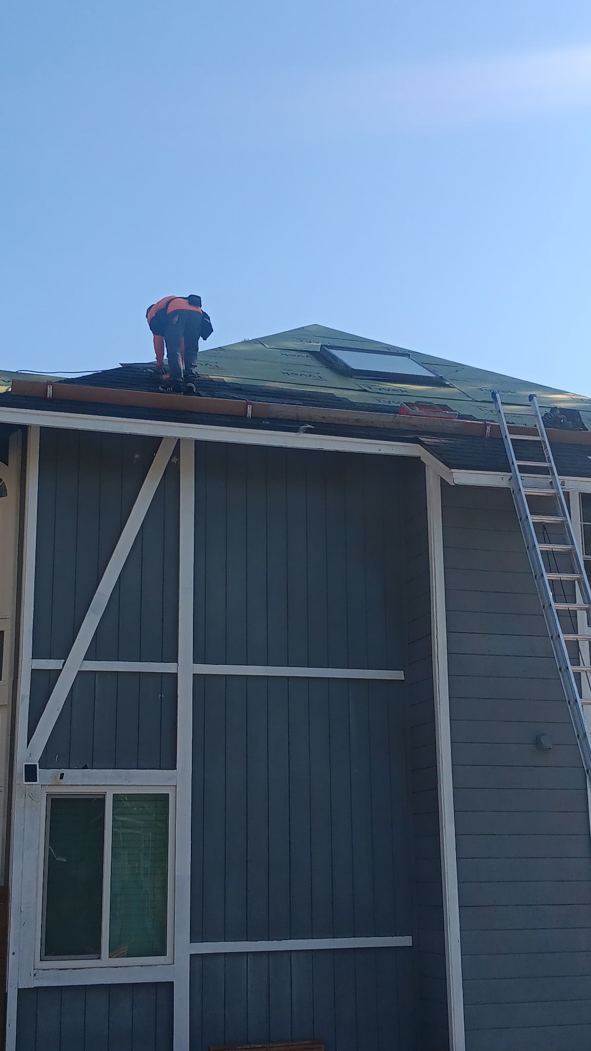 A man is working on the roof of a house.