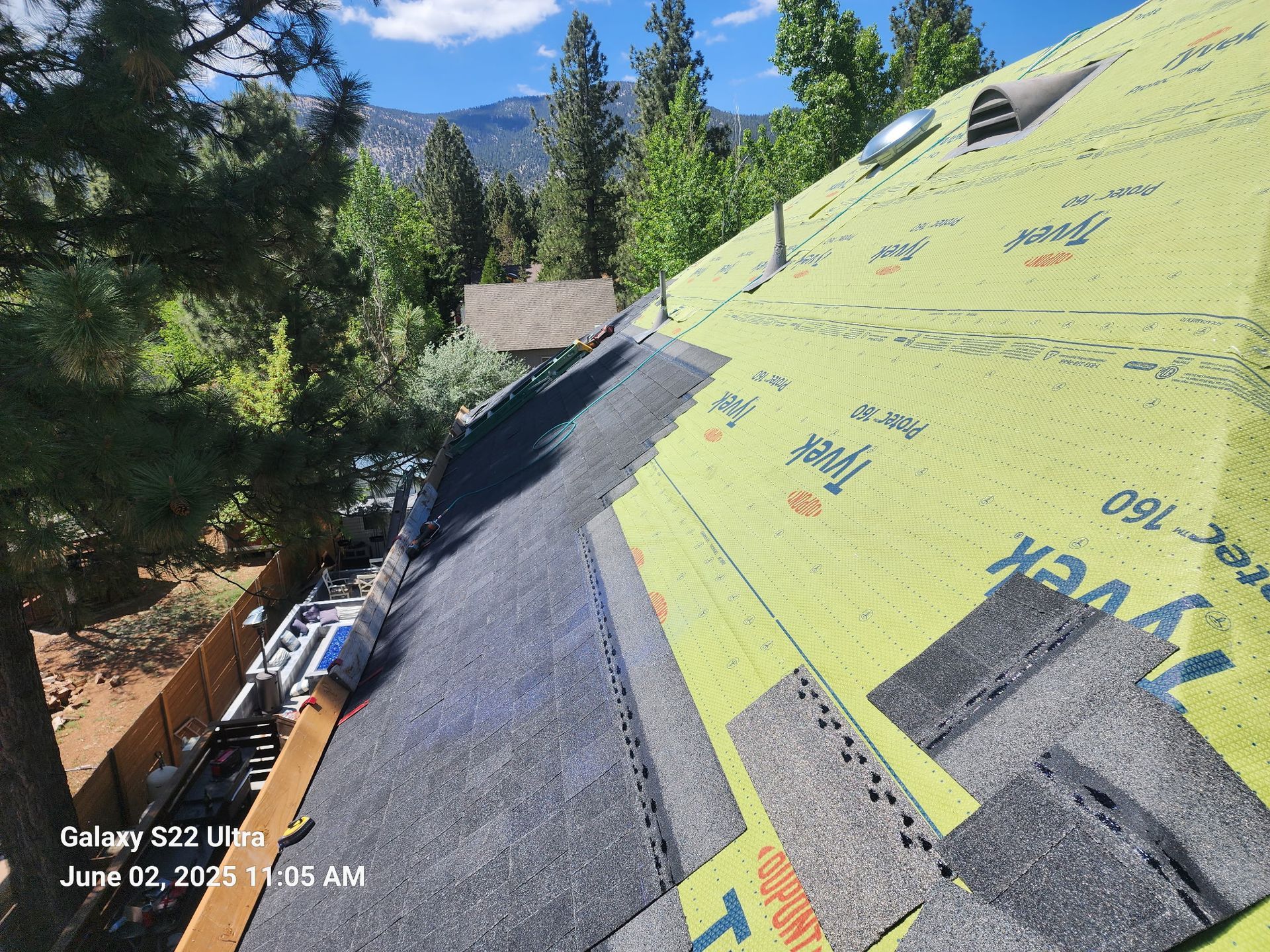 A roof with a lot of shingles on it is being installed.