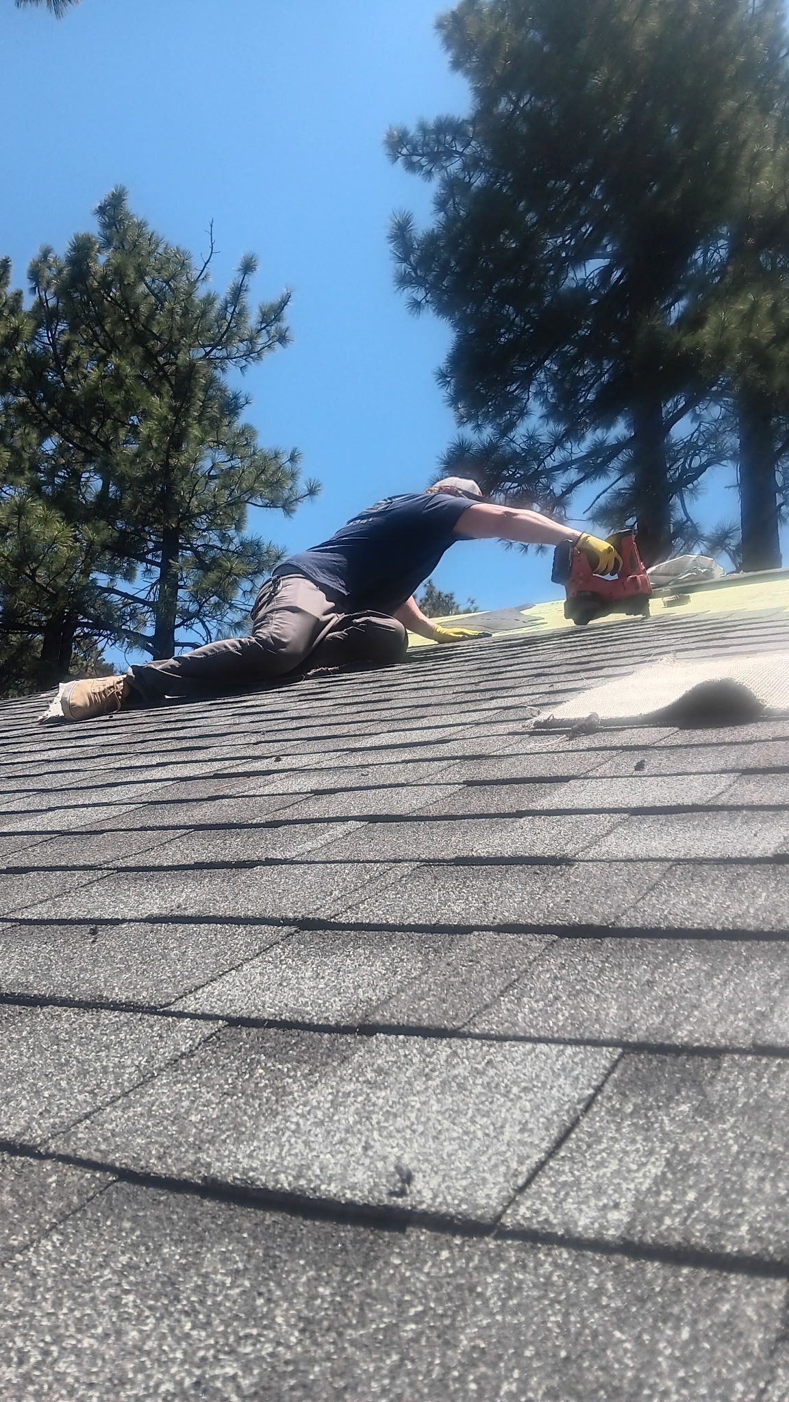 A man is working on the roof of a house.