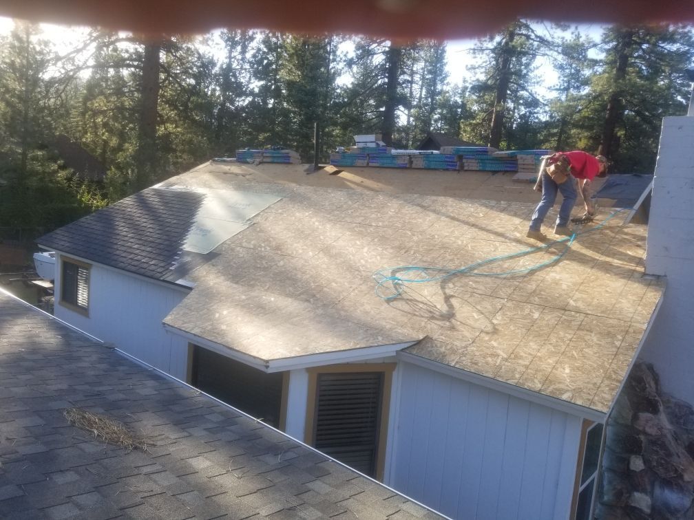 A man is working on the roof of a house.