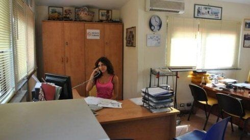 Una donna è seduta a una scrivania e parla al cellulare