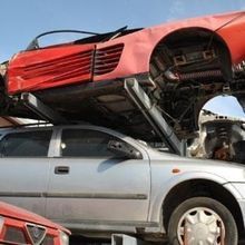 Un'auto rossa è parcheggiata sopra un'auto argentata.