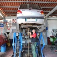 Un uomo sta lavorando su un'auto in un garage.