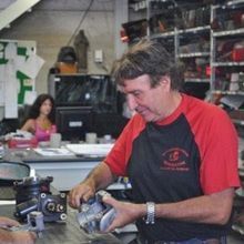 Un uomo sta lavorando su un pezzo di equipaggiamento in un garage.