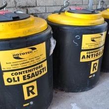 Due barili neri con i coperchi gialli sono uno accanto all'altro.