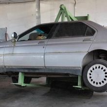 Un'auto è parcheggiata su un ponte sollevatore in un garage.