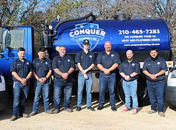 Conquer Plumbing & Air a blue and white company van is parked in front of a building .